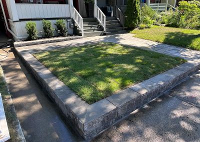 Raised rectangular lawn with stone wall by Berner Landscape, landscaping contractors in Scarborough.